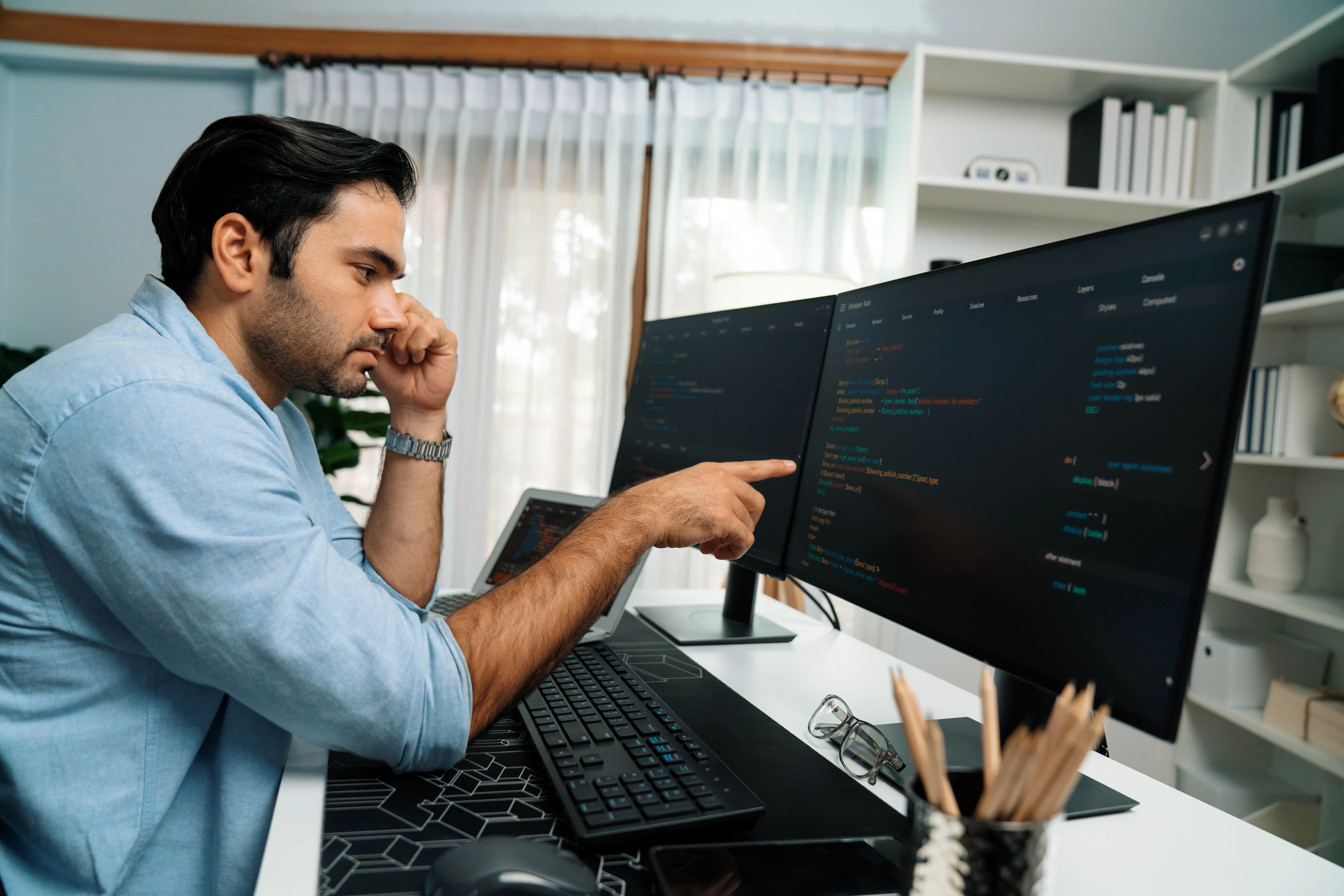 EVONET-Sicherheitsexperte analysiert Quellcode und Firewall-Regeln am Bildschirm für IT Security Hardening